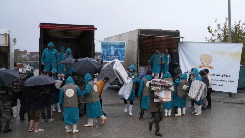 Foundation volunteers unloading aid trucks in the rain